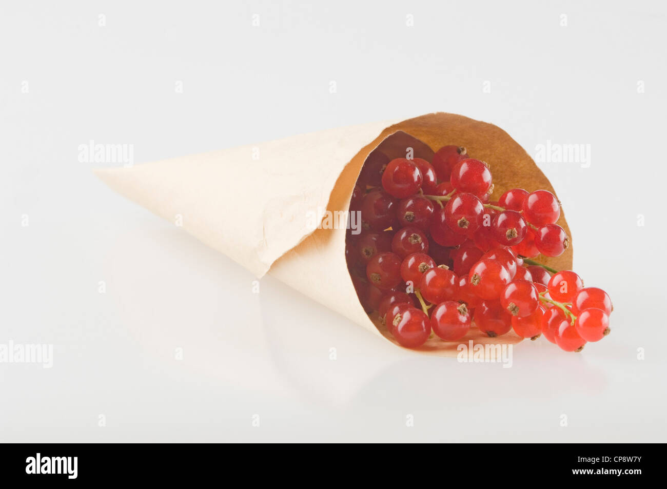 Rote Johannisbeeren in Papiertüte auf weißem Hintergrund Stockfoto