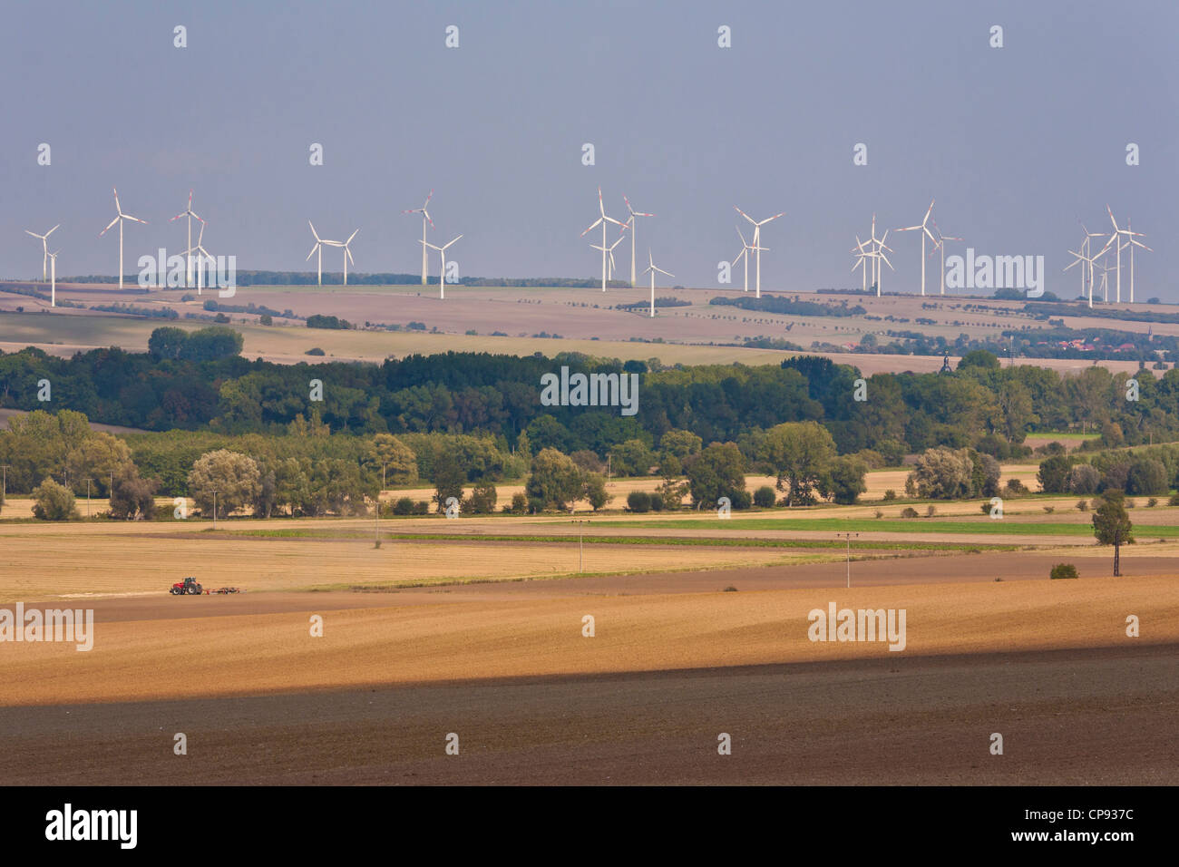 Deutschland, Thüringen, Blick auf Traktor im Feld mit Windrad im Hintergrund Stockfoto