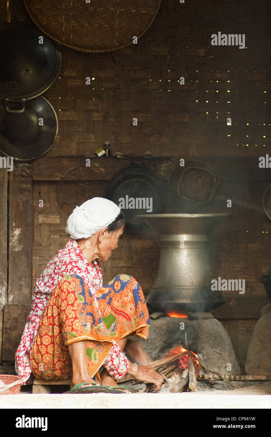 Ein Dorf Frau Kochen den Reis auf traditionellen Herd Stockfoto