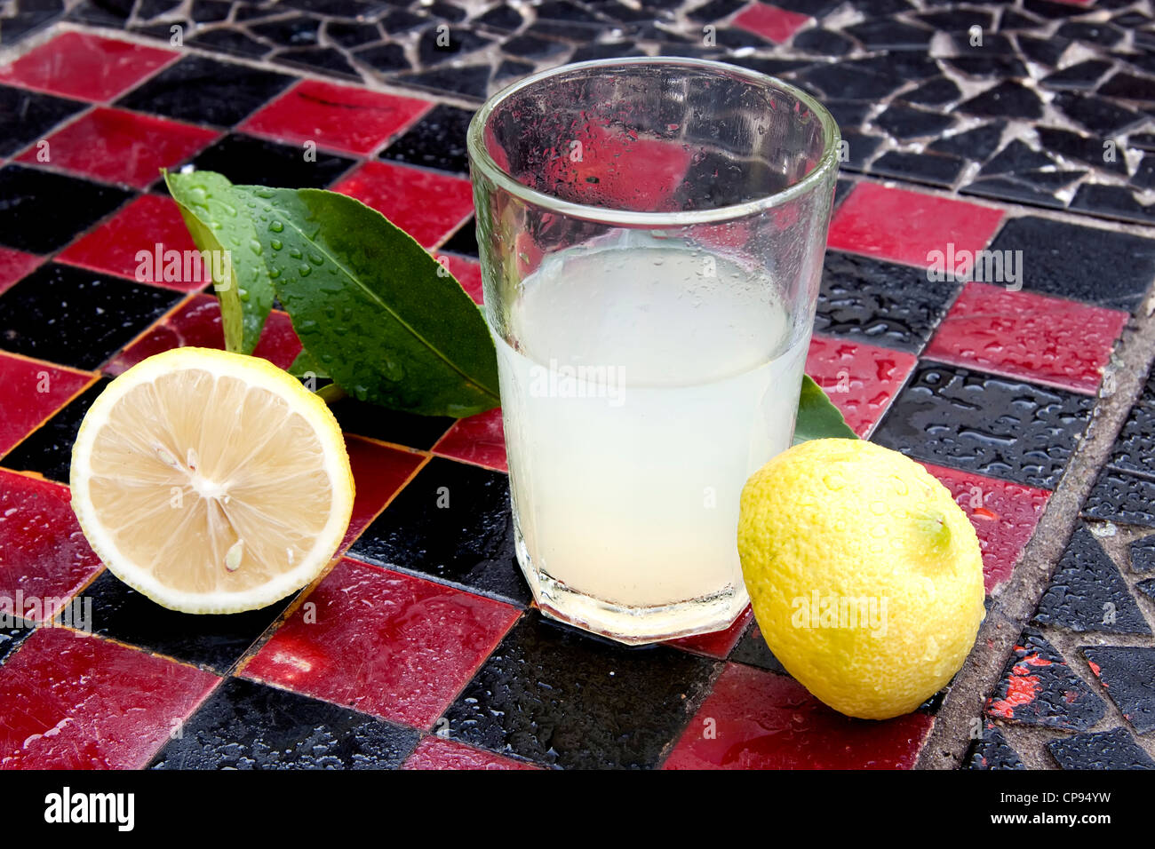 Zitronensaft und Zitronenschale auf dem Schachbrett Stockfoto