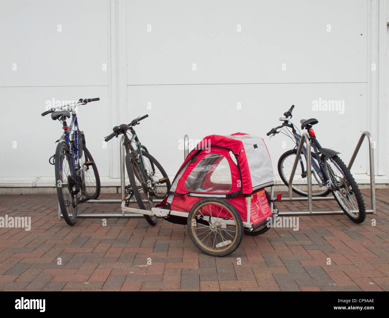 Fahrrad-Parkplatz mit Fahrrädern und Fahrrad-Anhänger. Stockfoto