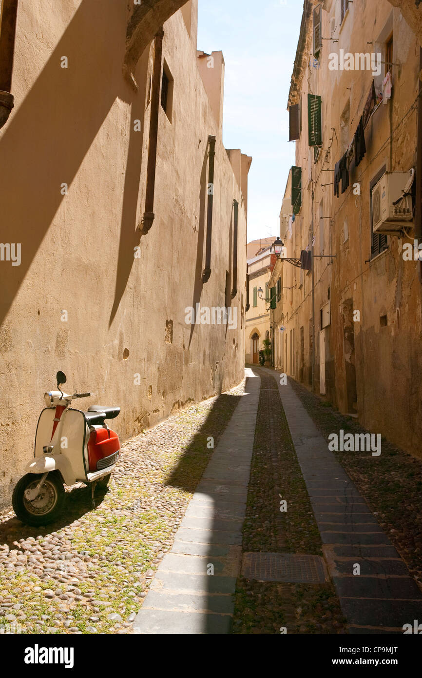 Scooter in den engen Gassen der Altstadt von Alghero geparkt. Stockfoto