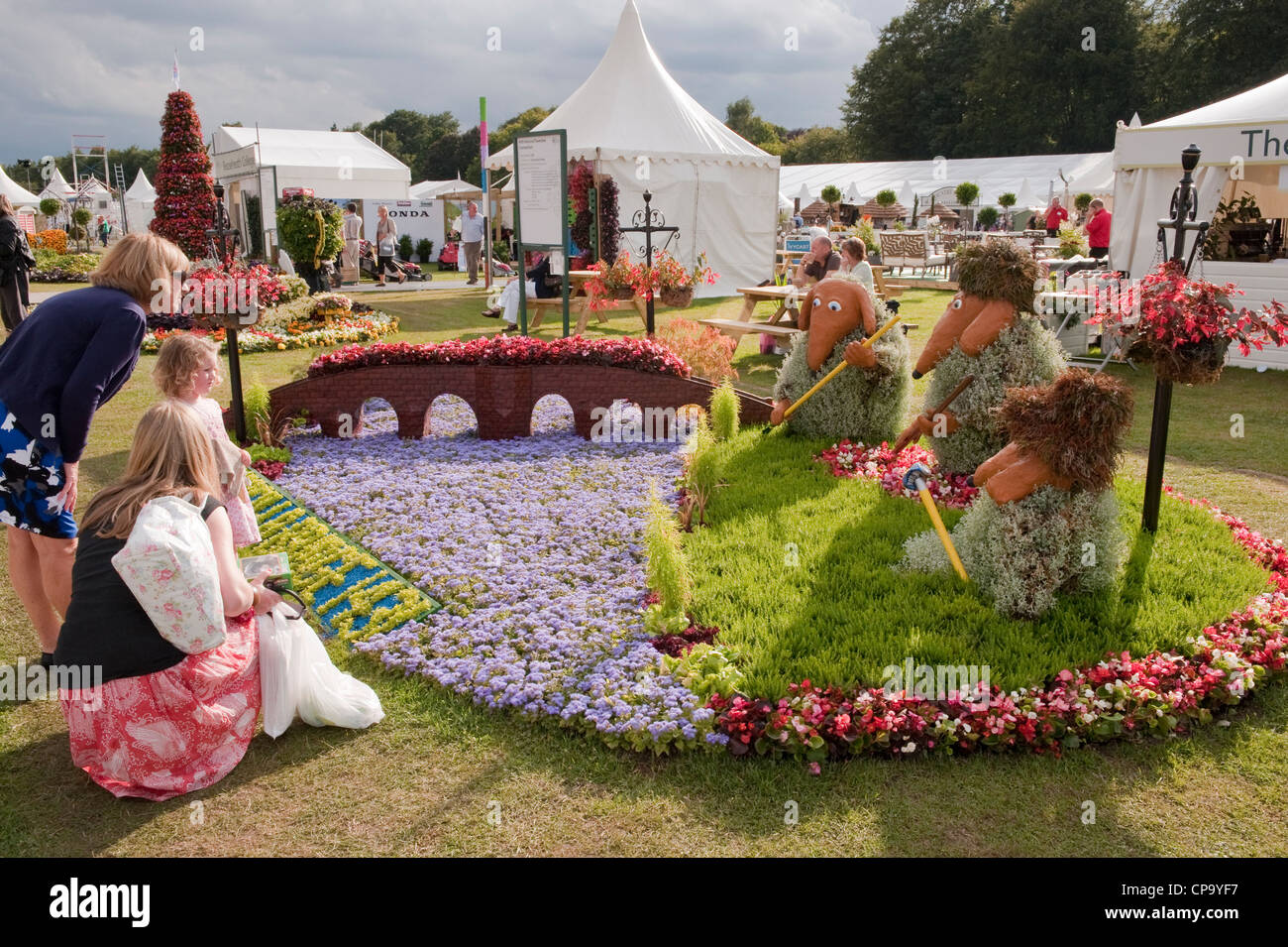 Frauen & kleine Kind Blick auf bunte Blume Bett Anzeige (Devorgilla Brücke & 3 Wombles) - RHS Flower Show, Tatton Park, Cheshire, UK. Stockfoto