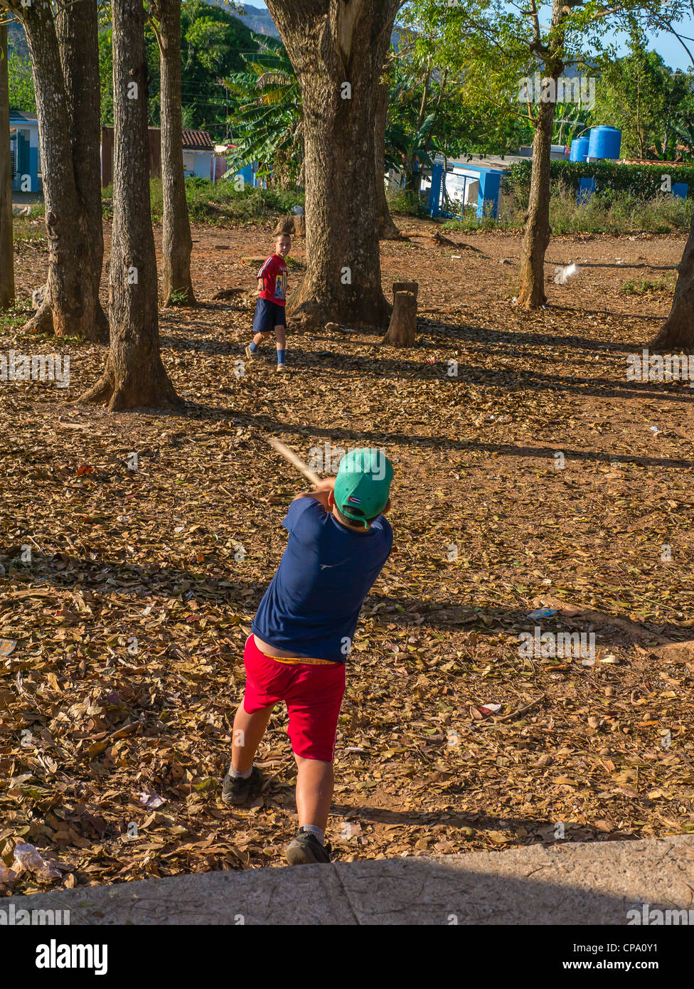 Zwei jungen kubanischen Spiel Stick Ball Baseball mit einem Stab für eine Fledermaus und eine Verschreibung Flasche für einen Ball im westlichen Kuba. Stockfoto