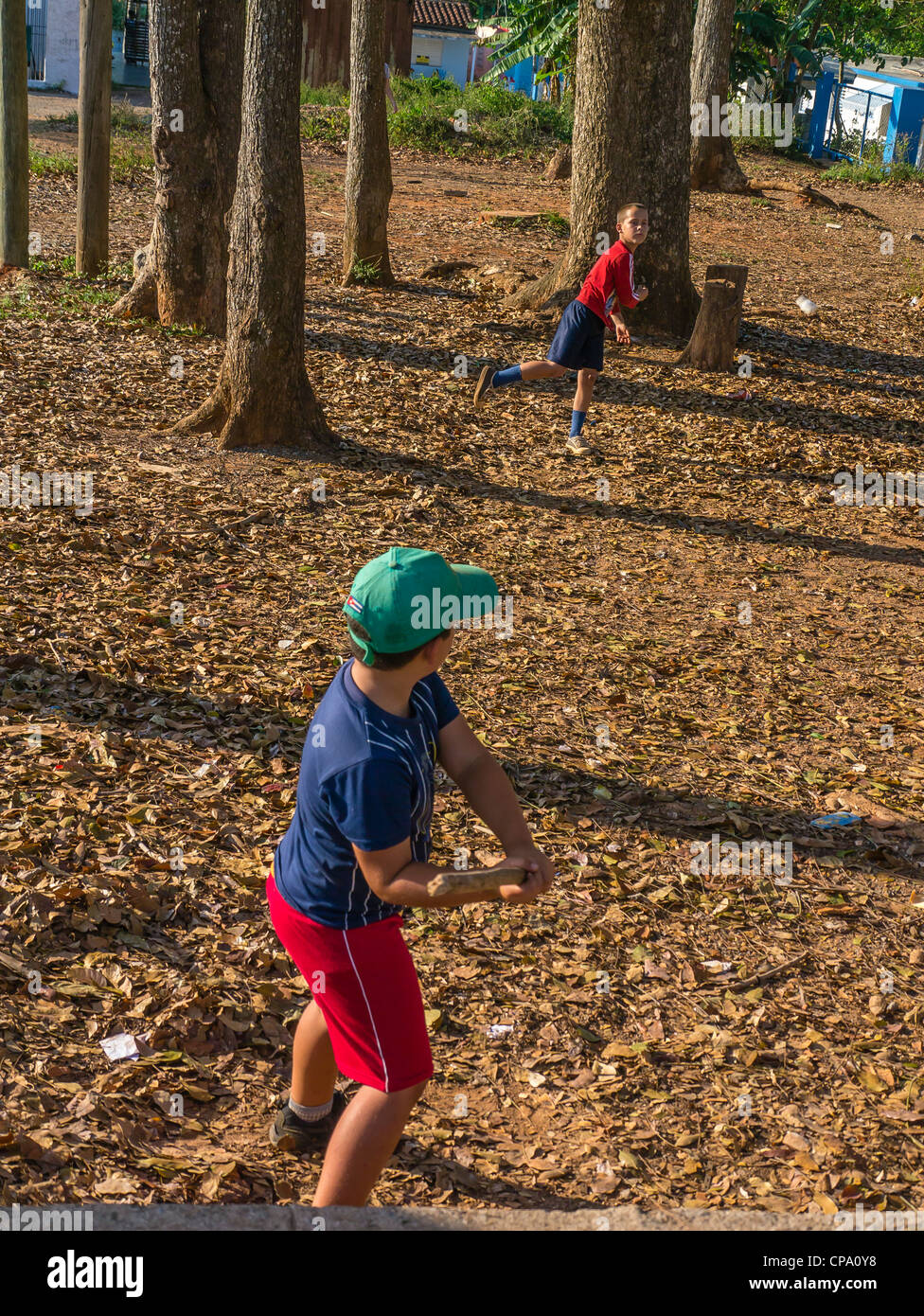 Zwei jungen kubanischen Spiel Stick Ball Baseball mit einem Stab für eine Fledermaus und eine Verschreibung Flasche für einen Ball im westlichen Kuba. Stockfoto