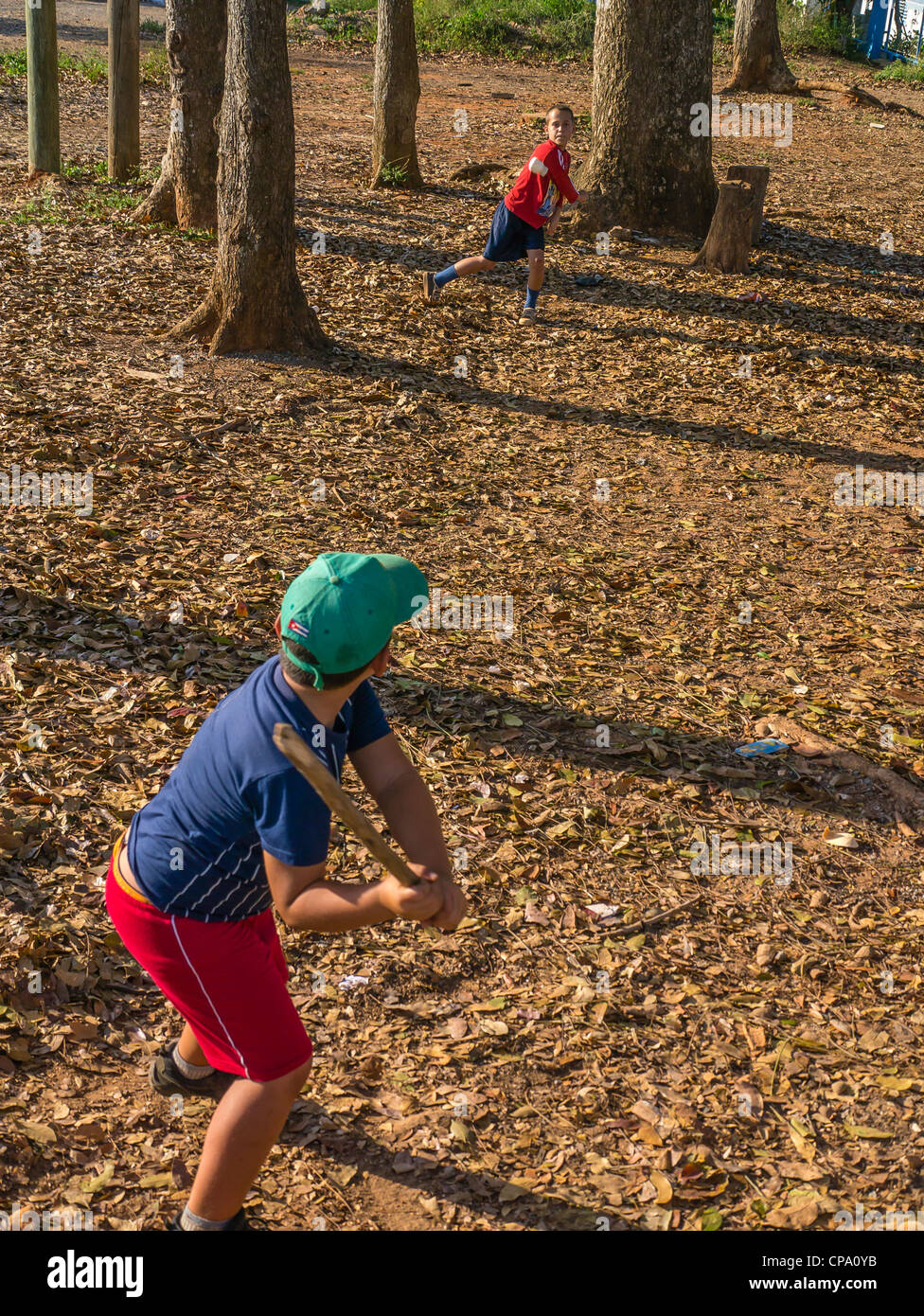 Zwei jungen kubanischen Spiel Stick Ball Baseball mit einem Stab für eine Fledermaus und eine Verschreibung Flasche für einen Ball im westlichen Kuba. Stockfoto