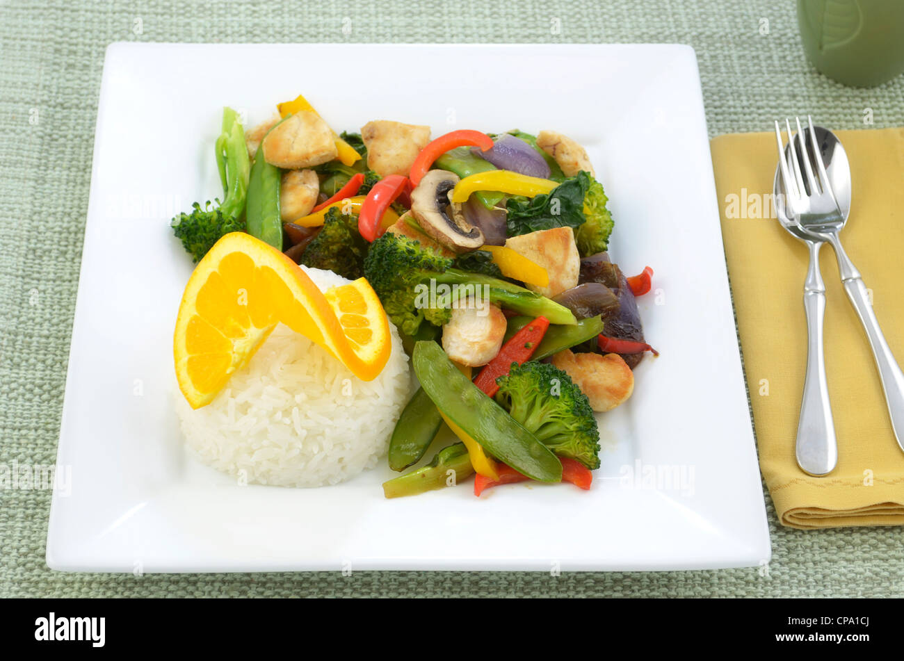 Hähnchen-Wok mit Reis auf quadratische weiße Teller Stockfoto