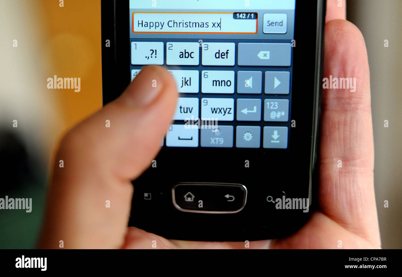 Mit Hilfe einer mobilen Smartphones Frohe Weihnachten SMS senden Stockfoto