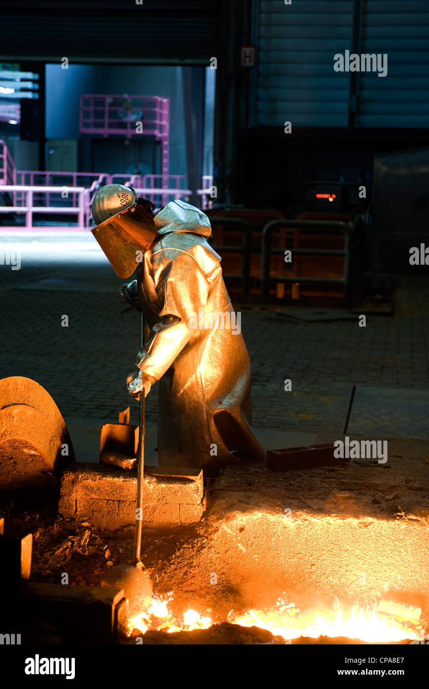 Eine Arbeitskraft, die Entnahme einer Probe von Roheisen, Duisburg, Deutschland Stockfoto