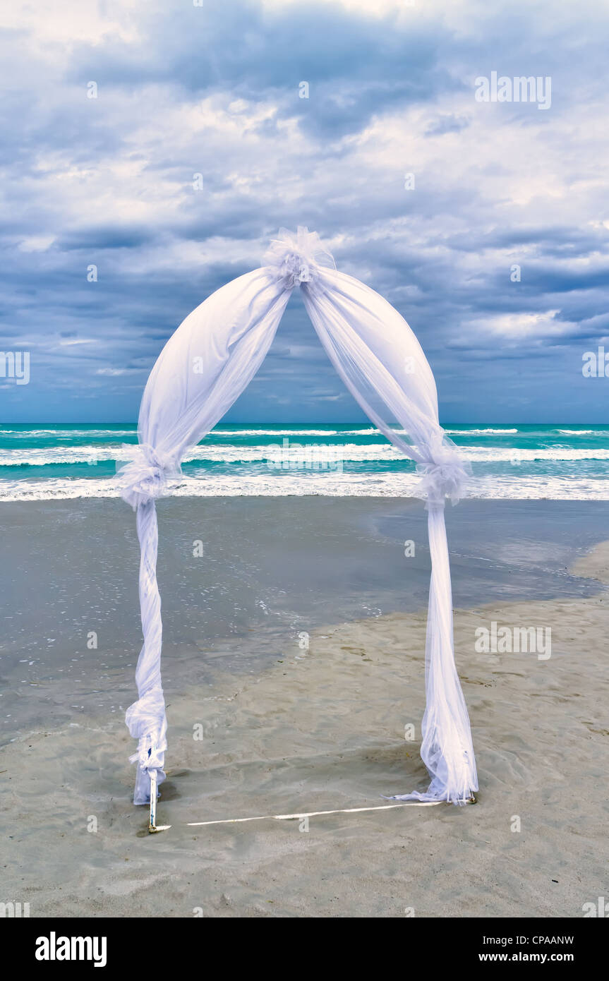 Hochzeit-Torbogen angeordnet auf dem Sand in der Vorbereitung für eine Strand-Hochzeits-Zeremonie Stockfoto