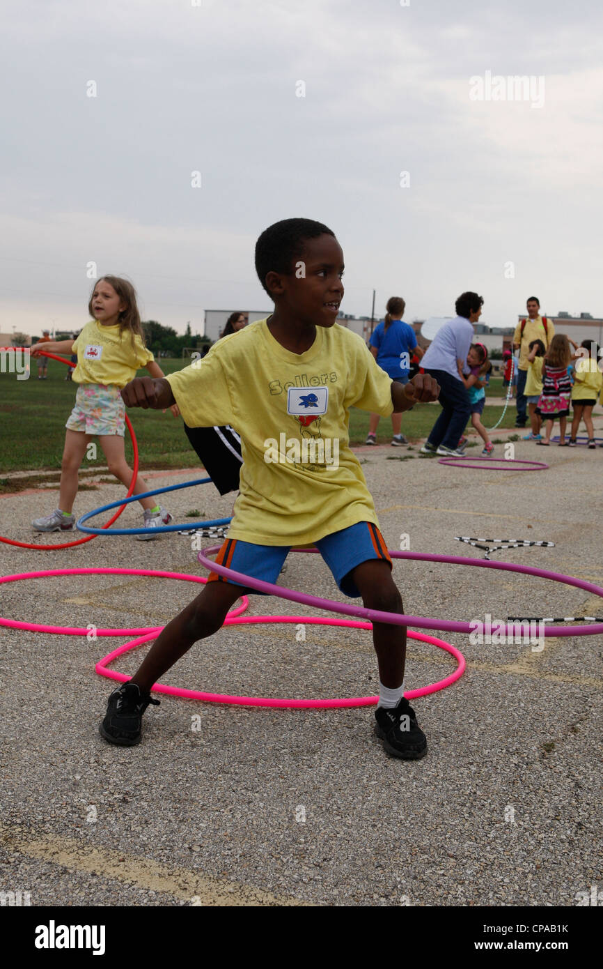 Multi-ethnischen Grundschulkinder genießen den Hula-hoop während körperlicher Aktivitäten während des Schultages Stockfoto