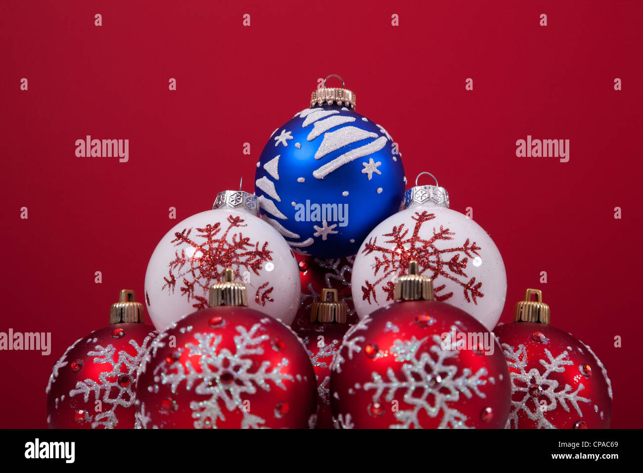 bunte Weihnachtskugeln über den Schnee mit einem roten Hintergrund (Tiefenschärfe) Stockfoto