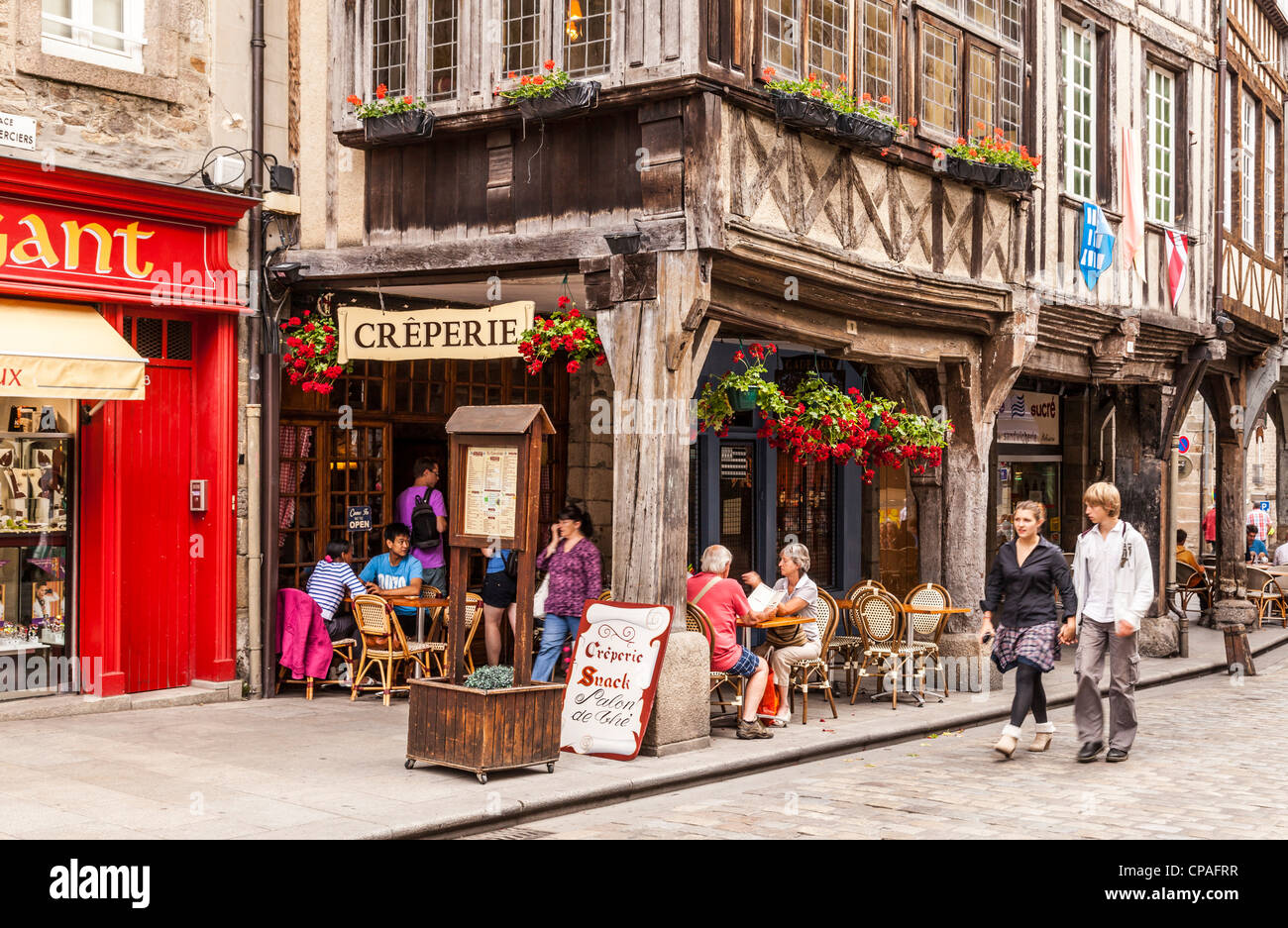 Menschen sitzen und Essen in einer Creperie in Ort des Merciers, Dinan, Bretagne, Frankreich. Stockfoto