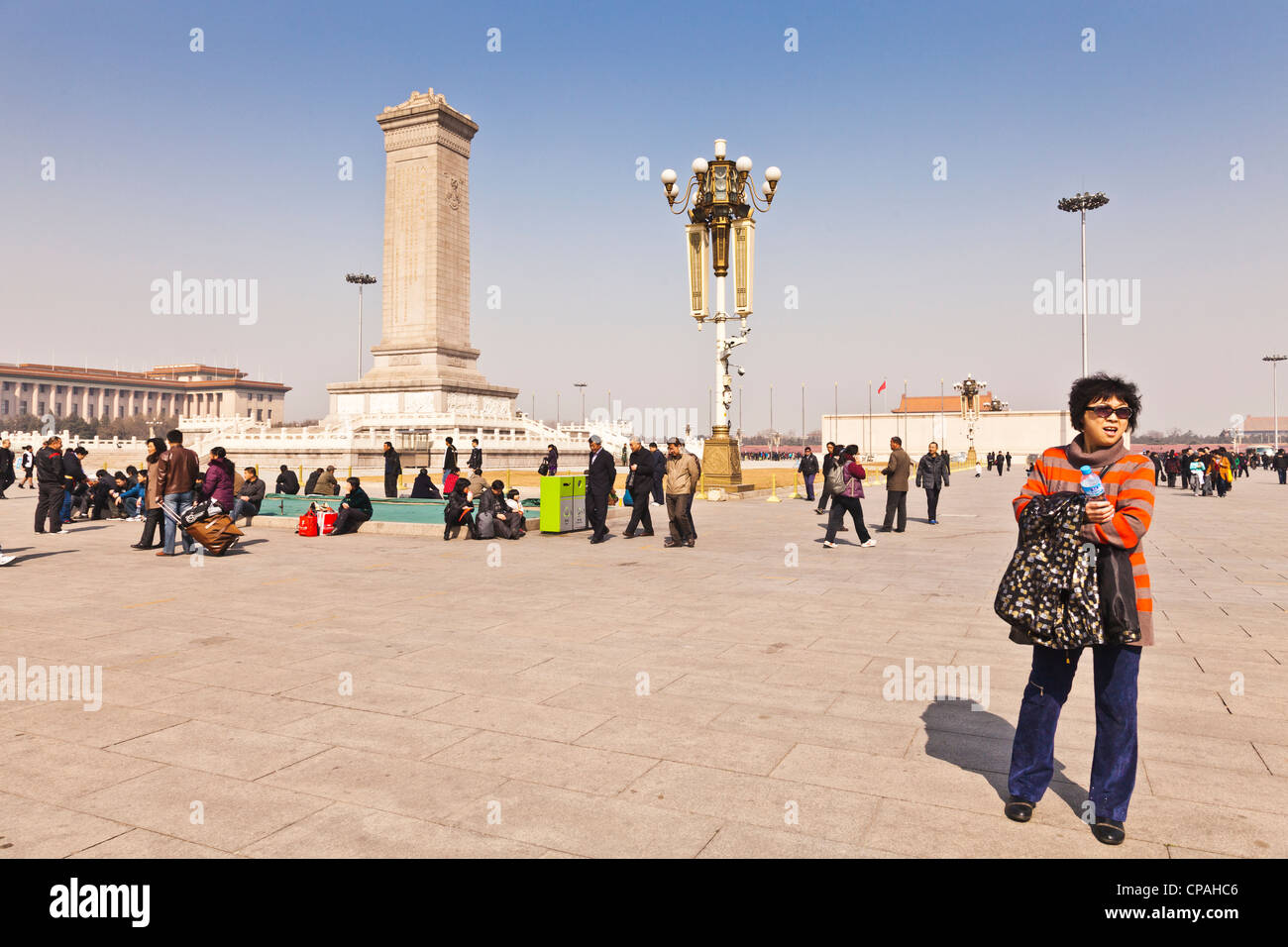 Touristen im Tiananmen Square, Beijing, China. Der Obelisk ist das Denkmal für die Helden der Revolution. Stockfoto