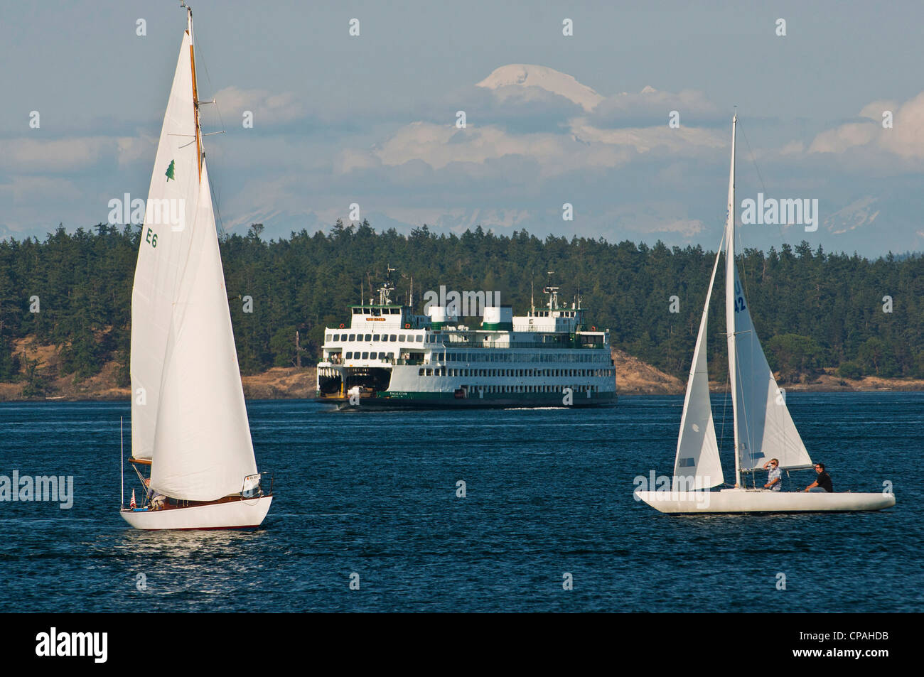 Mit der Fähre nähert sich Friday Harbor auf der San Juan Insel umrahmt von Segelbooten. Shaw Island und Mt Baker Hintergrund. Stockfoto