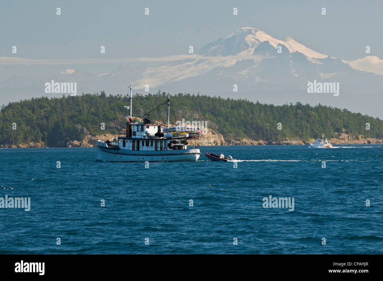 USA, WA, San Juan Inseln. Mount Baker dominiert die Landschaft beim Bootfahren in San Juans. Schlepper für Kajaktouren ausgestattet. Stockfoto