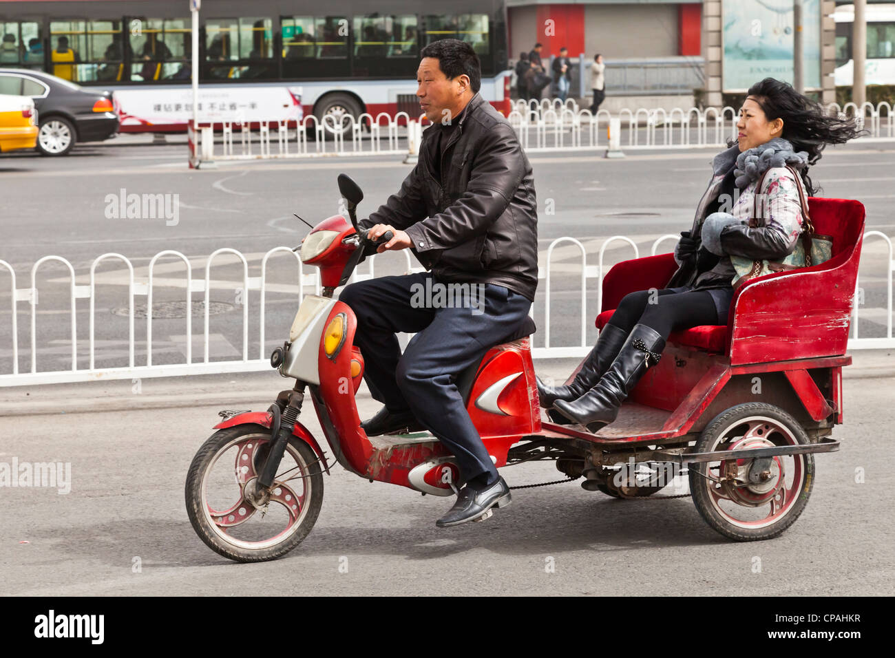 Frau getrieben in eine elektrische Rikscha, Tiantan Dong Road, Beijing, China. Stockfoto