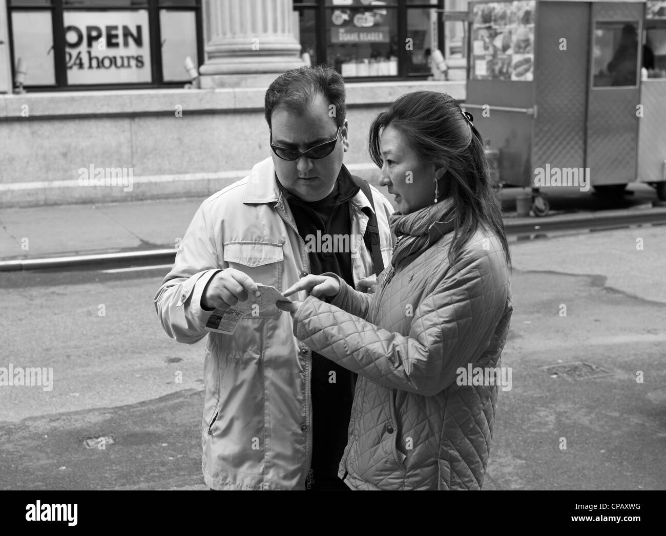 Ein Mann und eine Frau zu besprechen, wo sie sind und wie man wohin sind sie in New York City. Stockfoto