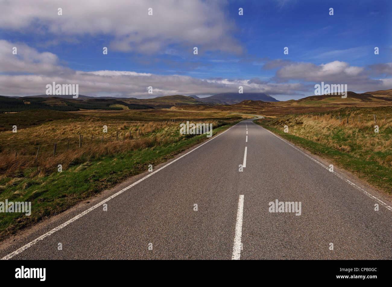 Lange gerade leere Straße in dramatischen Landschaft, Sutherland, Nordschottland. Stockfoto