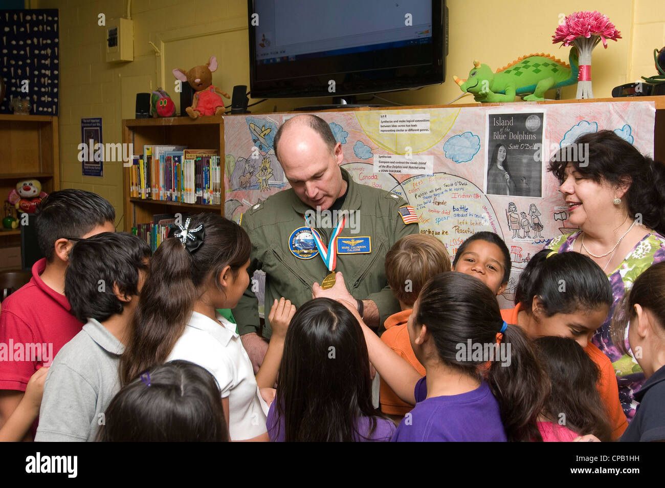 Studenten aus Culk Elementary versammeln sich um Cmdr. Mark Calderon, um seine Goldmedaille zu sehen, nachdem er mit den Studenten über seine Leistungen im Laufe der Jahre gesprochen hat. Calderon, der die USA bei vier Weltmeisterschaften von 1980 bis 86 vertreten hatte, gewann mit Stuart Ransom den Weltmeistertitel 1982. Calderon war in der US Navy, als er für die U. S. Trampolin Team für ein viertes Mal im Jahr 1986 qualifiziert. Calderon wird zum Chef der Marineflugausbildung ernannt und wird diesen Sommer in die U.S. Turner Hall Fame 2012 aufgenommen. Stockfoto