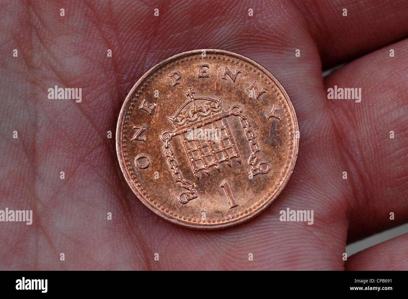Eine Pence-Münze in die Handfläche. Stockfoto
