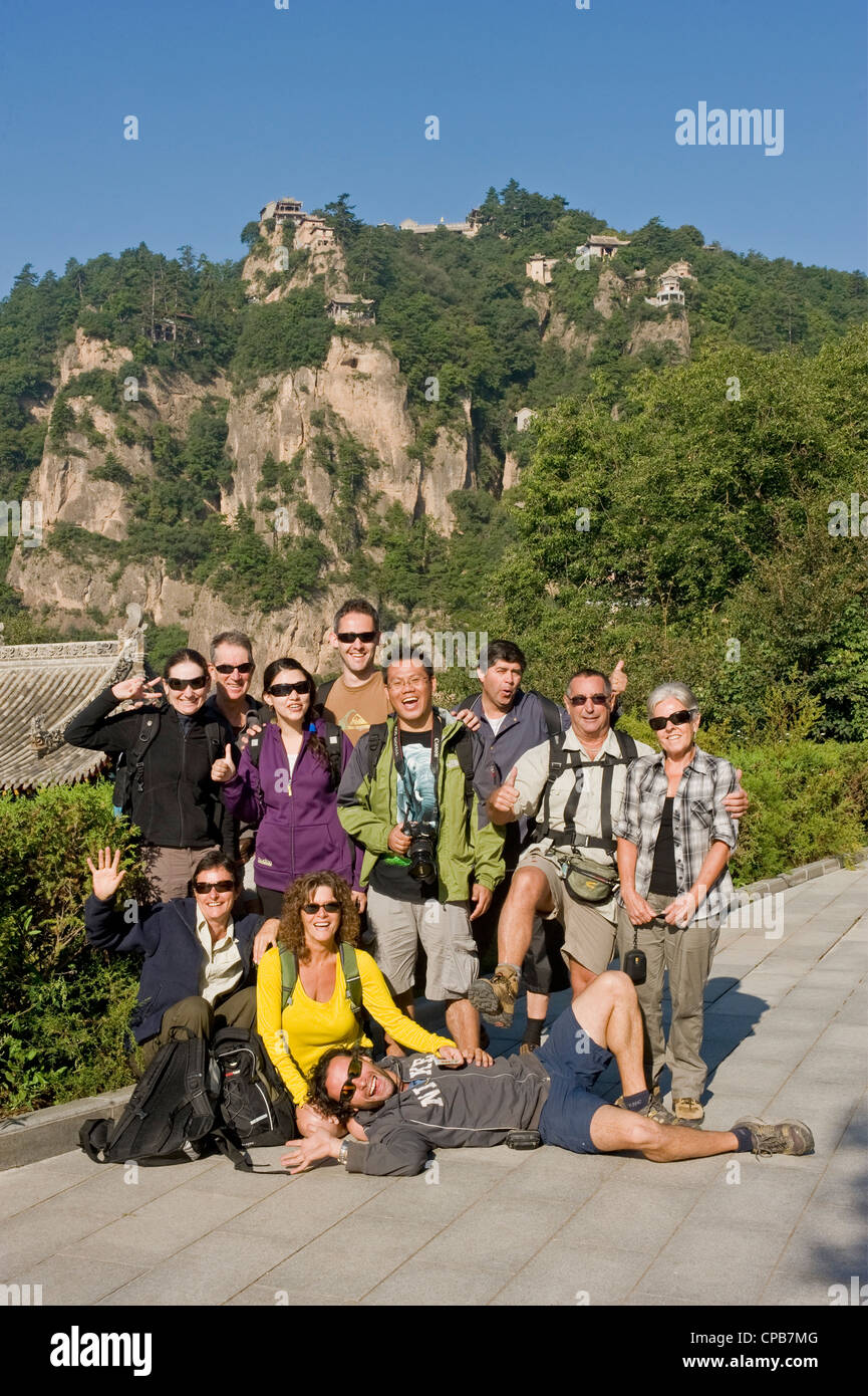 Eine Gruppe von europäischen Touristen posieren für die Kamera mit Thunderclap Gipfel des Berges Kongtong im Hintergrund. Stockfoto