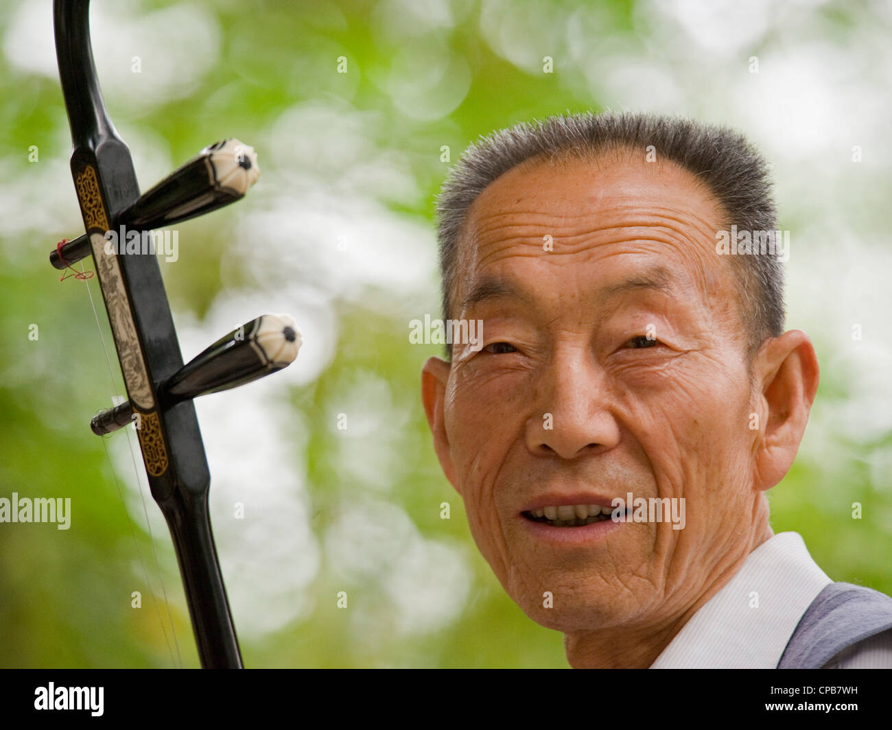 Ein chinesischer Musiker spielen das traditionelle chinesische Instrument, Erhu - chinesische Violine, am frühen Morgen in einem Park in Pingliang. Stockfoto