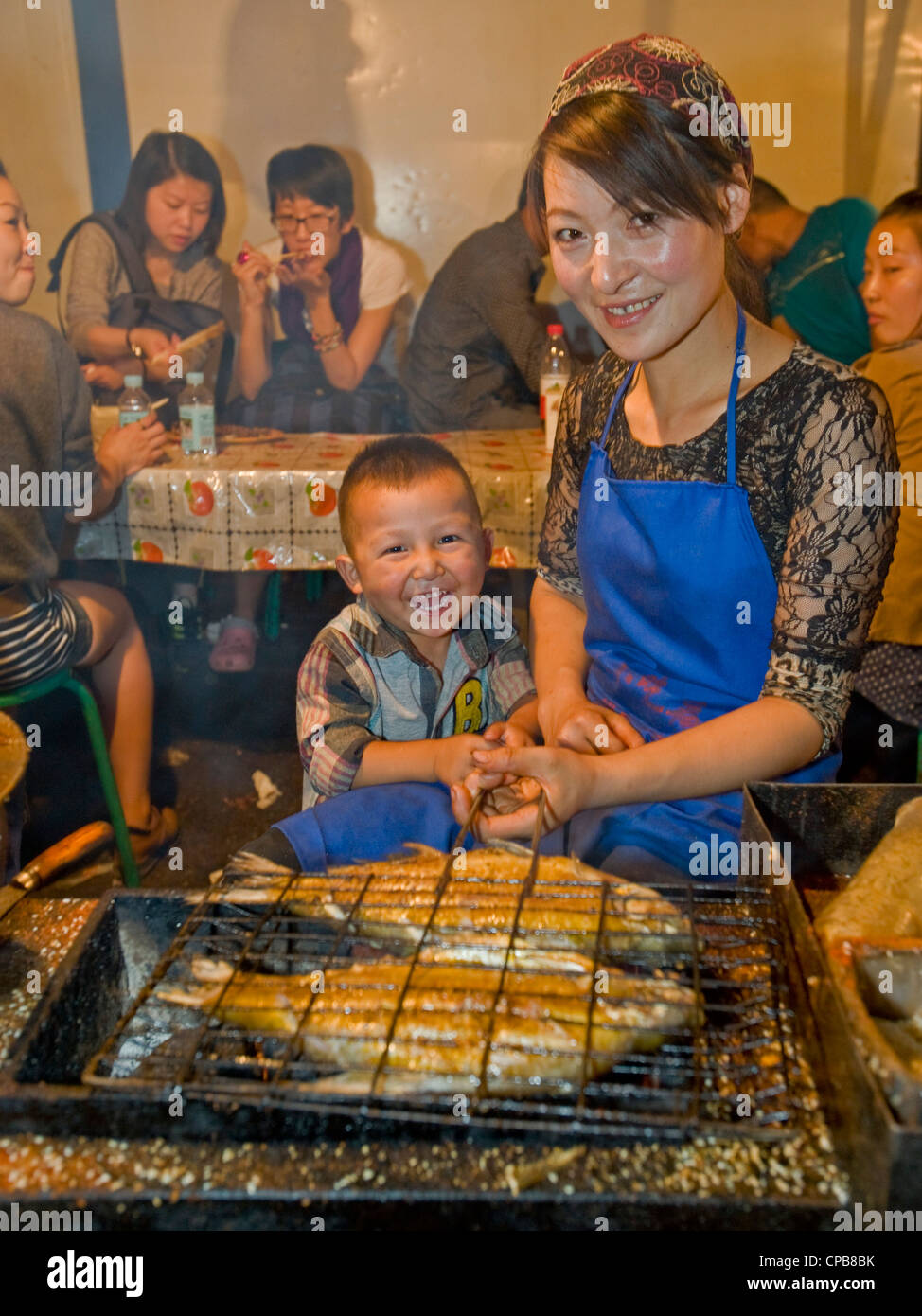Vorbereitung gegrillt und gewürzten Fisch Snacks auf dem bekannten Zhengning Straße Essen street Nachtmarkt in Lanzhou. Stockfoto