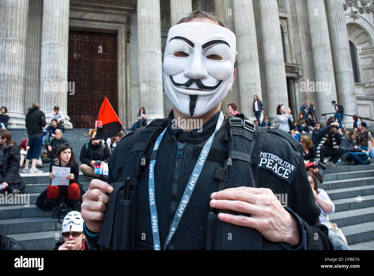Besetzen, London UK. Demonstration gegen Kapitalismus, Teil eines globalen Aktionstages. Demonstrant in anonymisierter Guy Fawkes Maske tragen 'Polizei Uniform'. Stockfoto