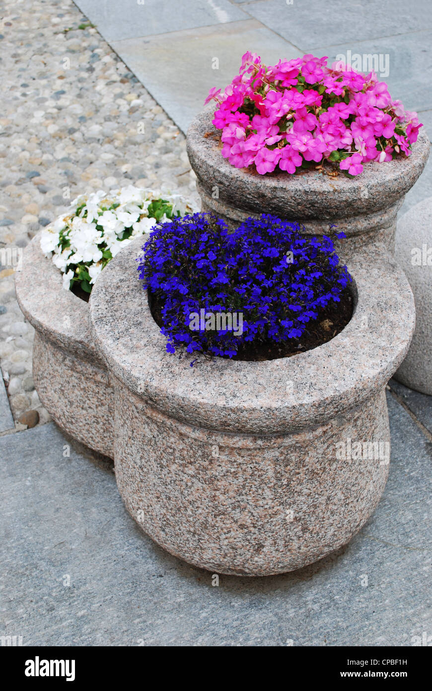 Bunte Blumen in Granit Blumentopf als Straßendekoration Stockfoto