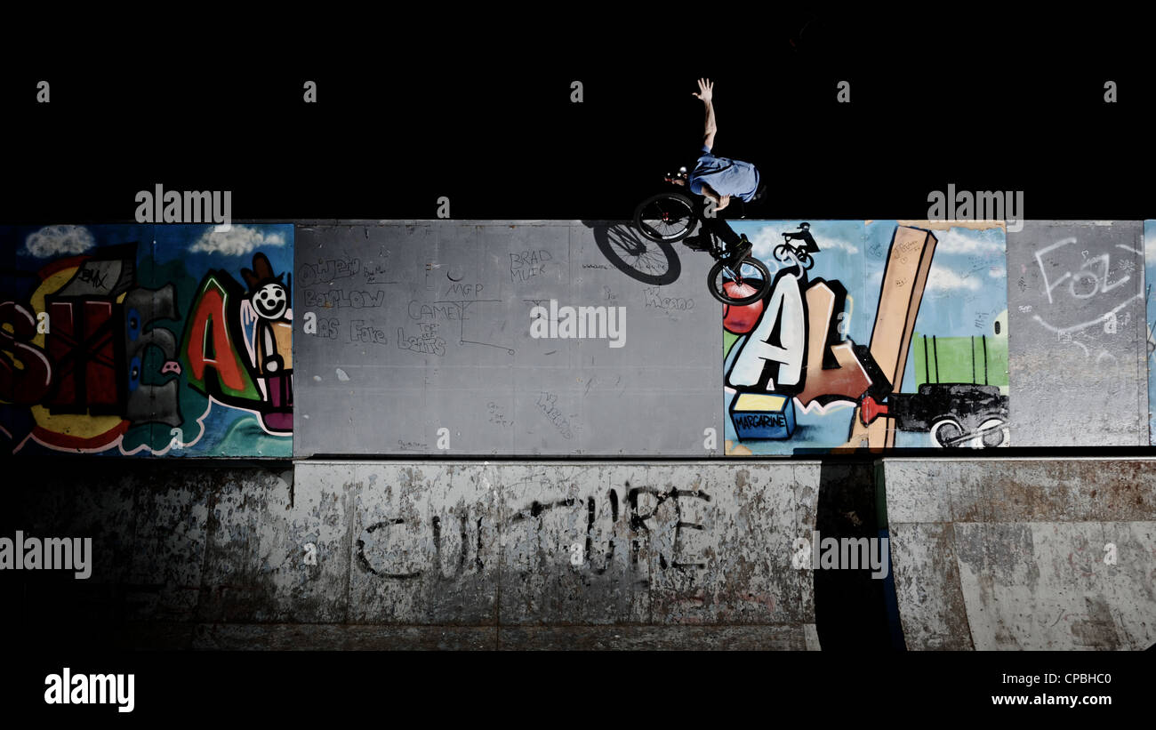 BMX rider führt Tricks bei einem indoor Skatepark. Stockfoto