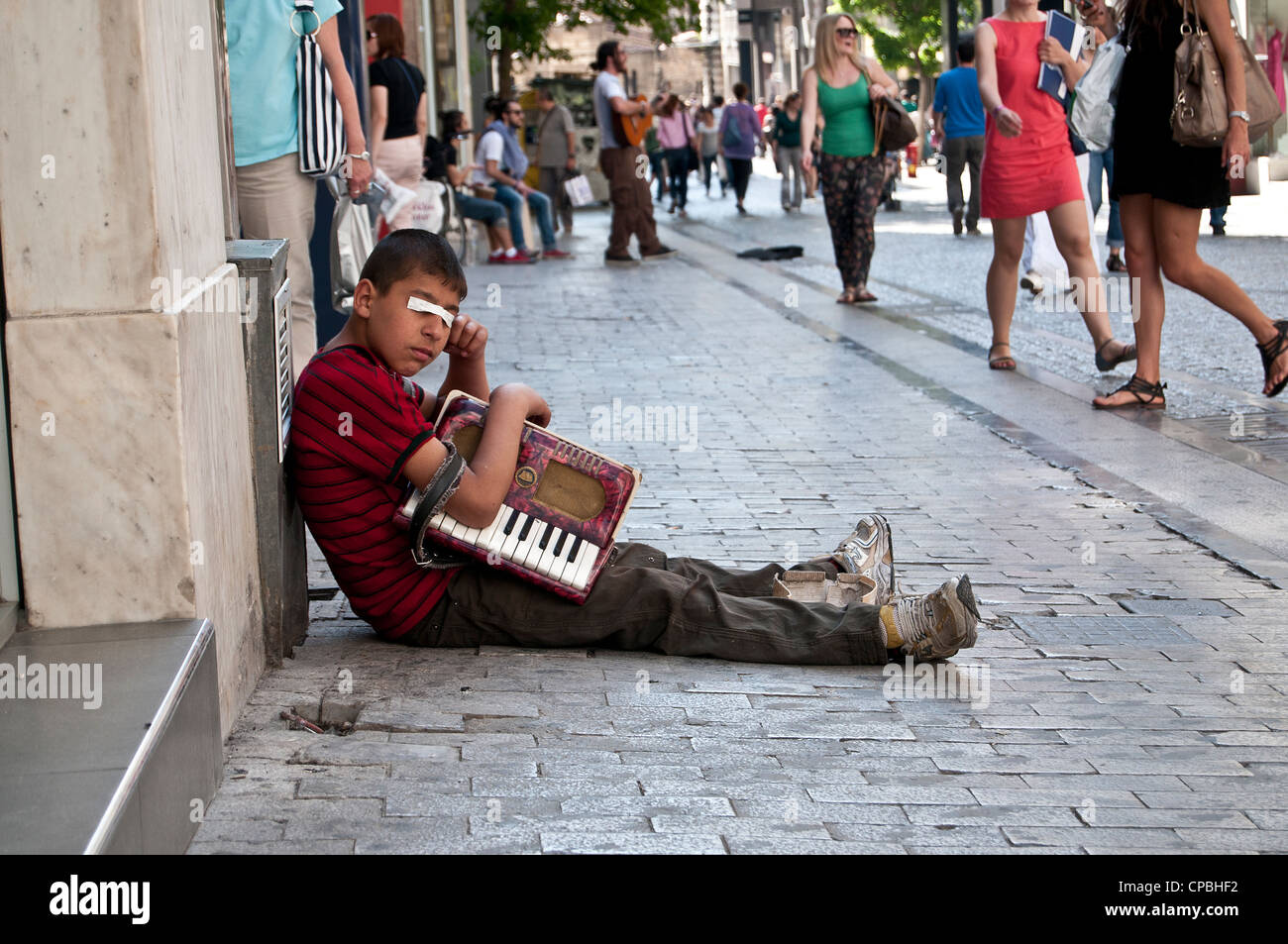 Kinder betteln mit Akkordeon auf Straße in Athen, Griechenland Stockfoto