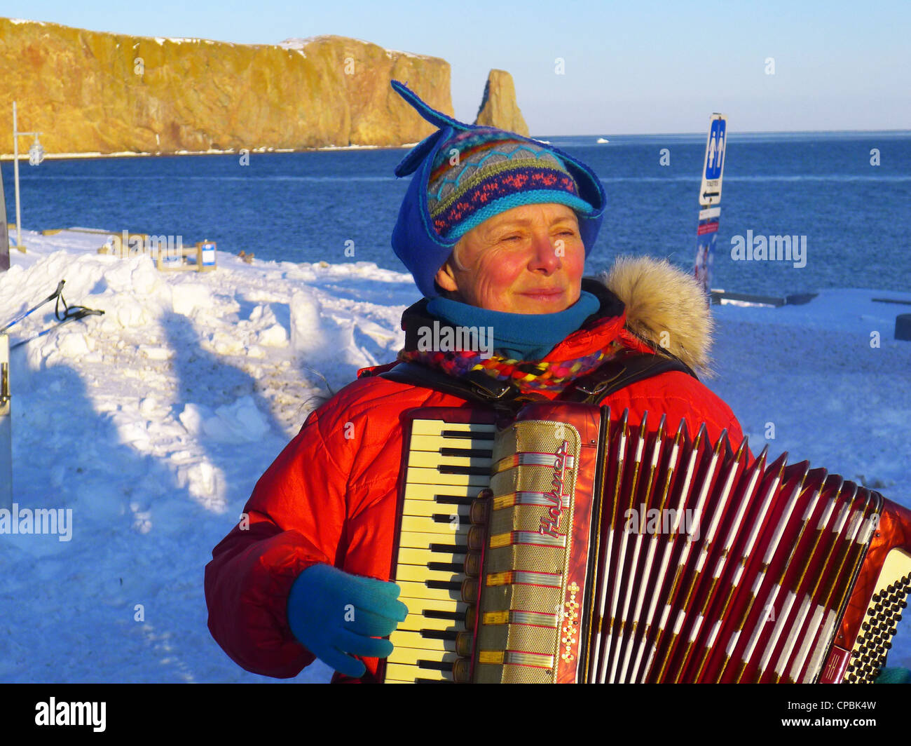 Eine Dame draußen spielt das Akkordeon im Winter in Perce, Gaspesie, Quebec Stockfoto