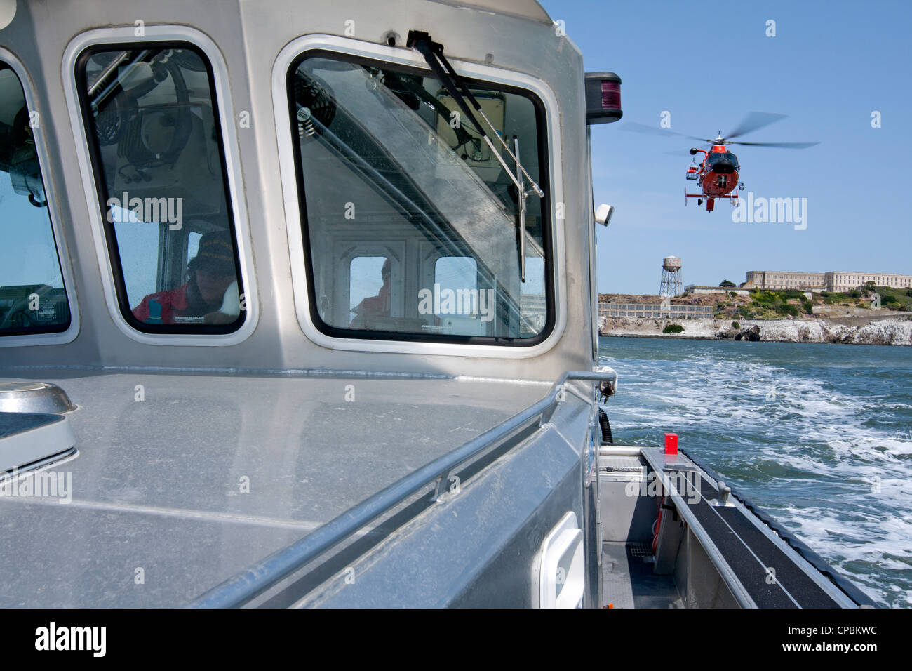 United States Coast Guard HH - 65C Dolphin Helikopter nähert sich ein Hilfs Coast Guard Schiff. Stockfoto