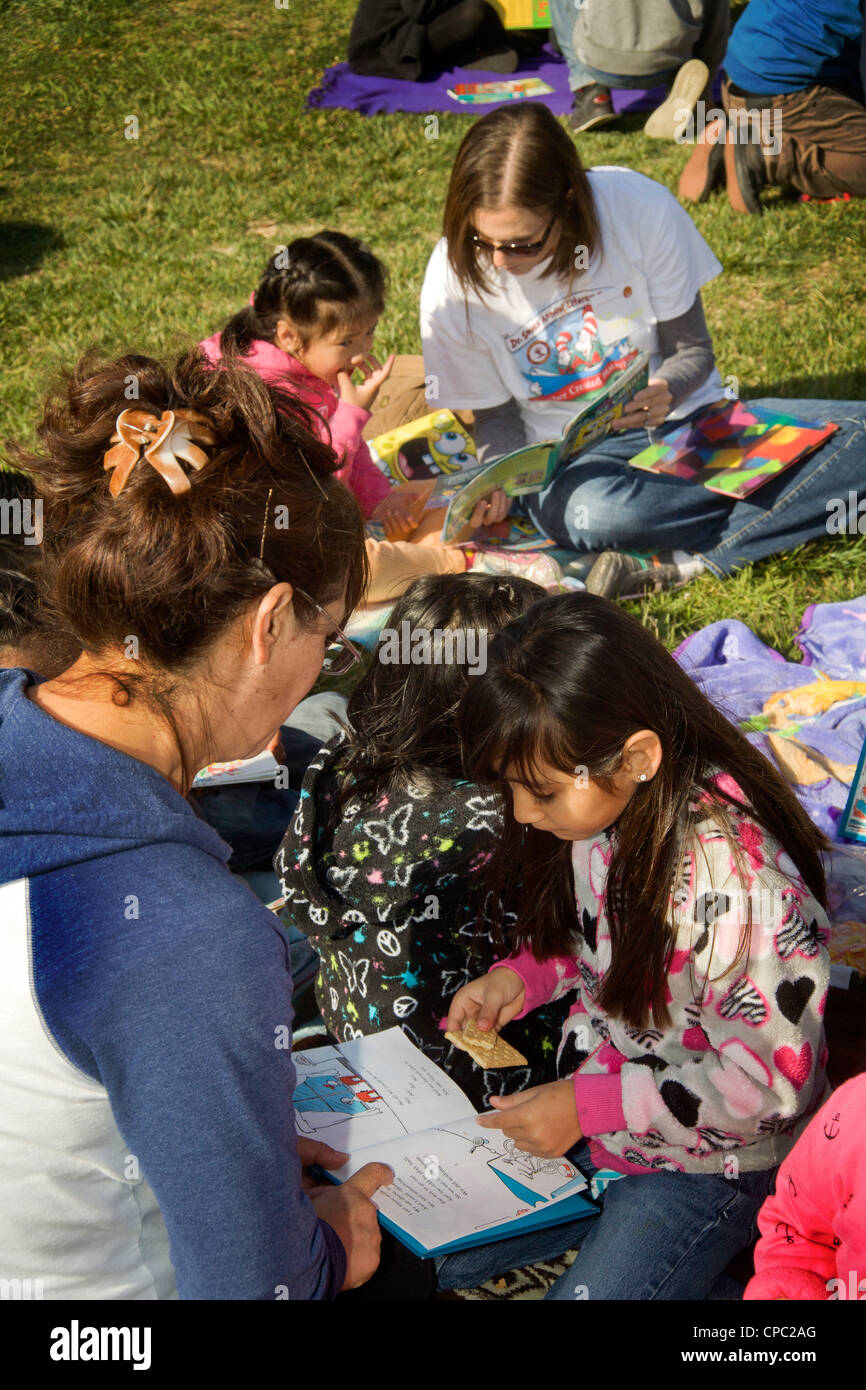 Freiwillige Lehrer ermutigen junge lokale hispanischen Mädchen auf einer im freien "Dr. Seuss jährliche Alphabetisierung Fair" an einer CA-Schule zu lesen. Stockfoto