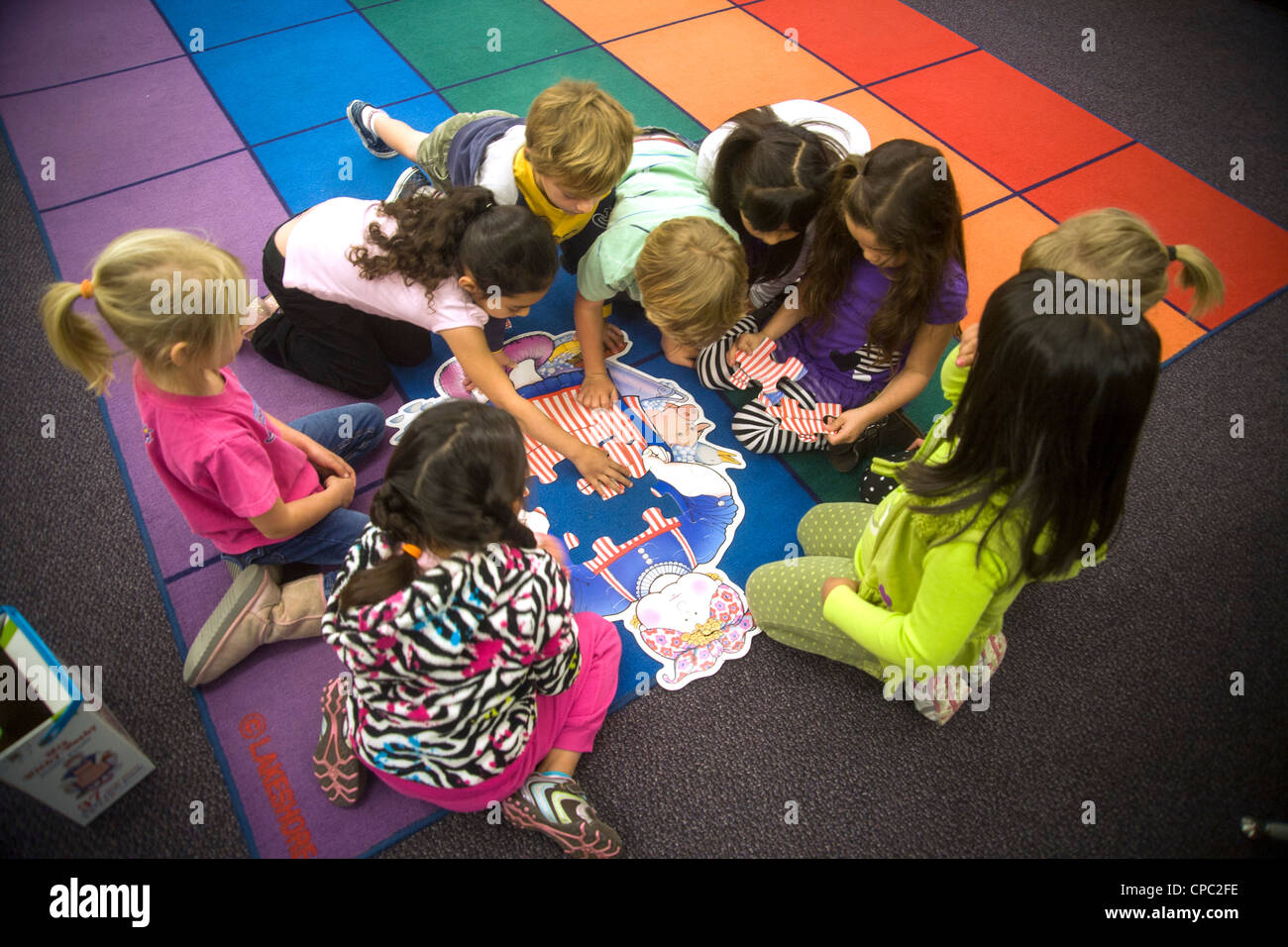 Erdgeschoss ein Klassenzimmer eine Gruppe von Kindergartenkindern zusammenarbeiten, um ein Puzzle in San Clemente, Kalifornien zu montieren. Stockfoto