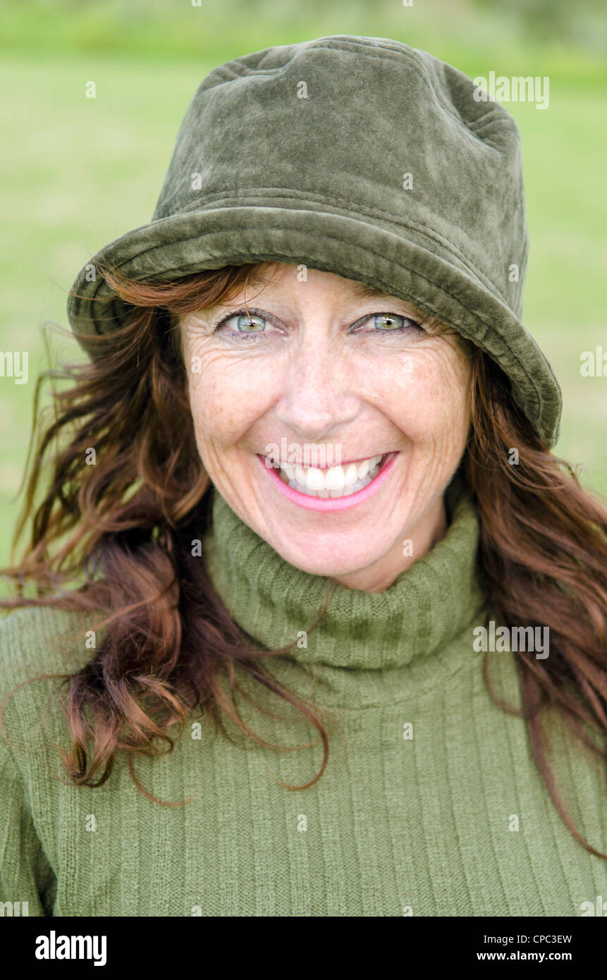 Ein Farbfoto-Porträt einer glücklich lächelnde Frau in den Vierzigern, grünen Hut. Stockfoto