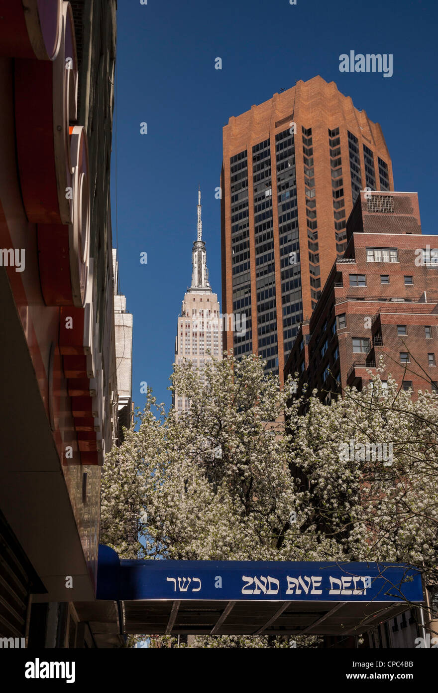 Straßenszene, E.33nd Seitenstraße 3nd Avenue, 2nd Avenue Deli Markise und Empire State Building in Hintergrund, Murray Hill, New York Stockfoto