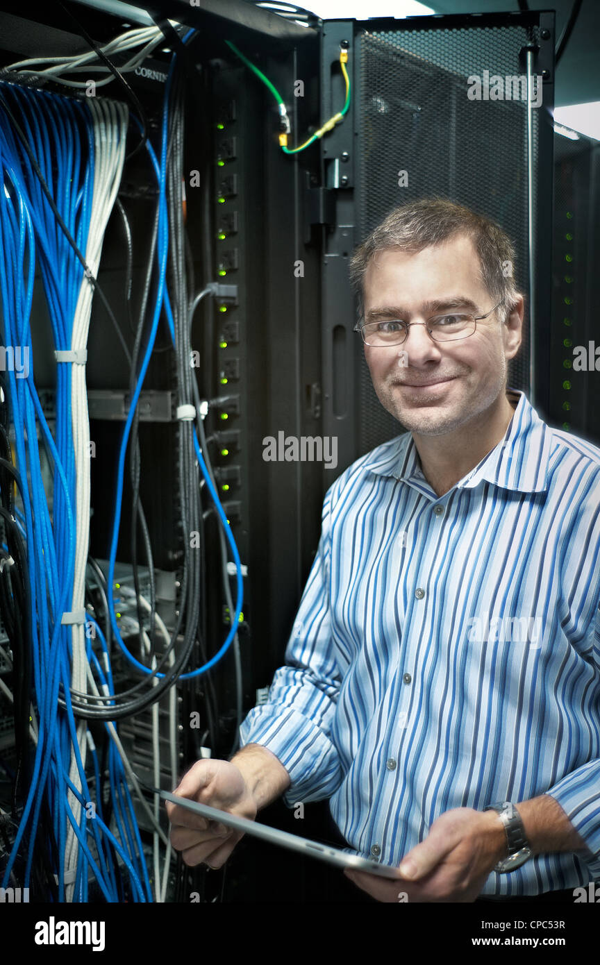 Ein Lächeln auf den Lippen Techniker Aufrechterhaltung eines riesigen Ethernet-Hubs. Stockfoto