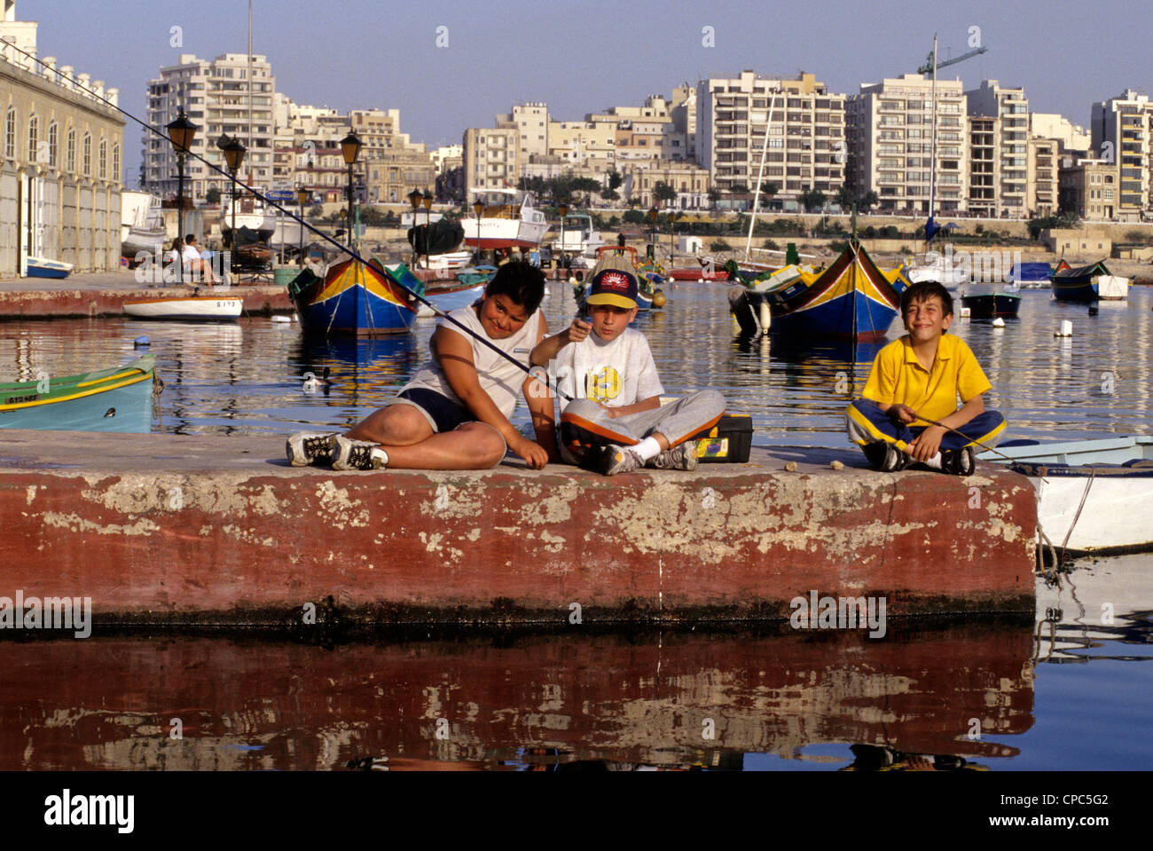 Spinola Bay, St. Julians, in der Nähe von Valletta, Malta. Maltesische jungen Fischen. Stockfoto