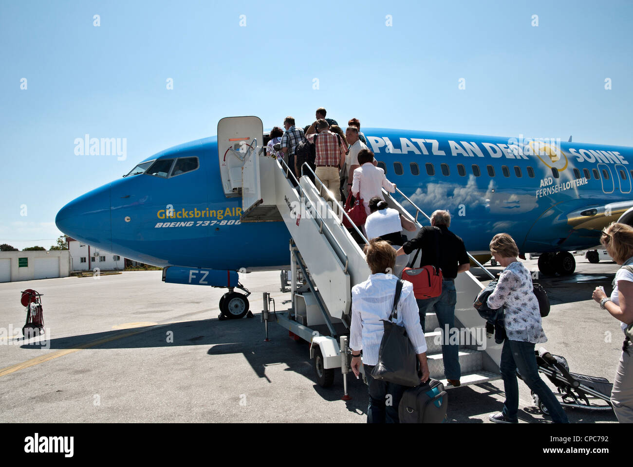 Passagiere geben Sie einer Boeing 737 von TUIfly über einen Gang in das Erscheinungsbild der ARD Fernseh-Lotterie ausgelegt ist. Stockfoto