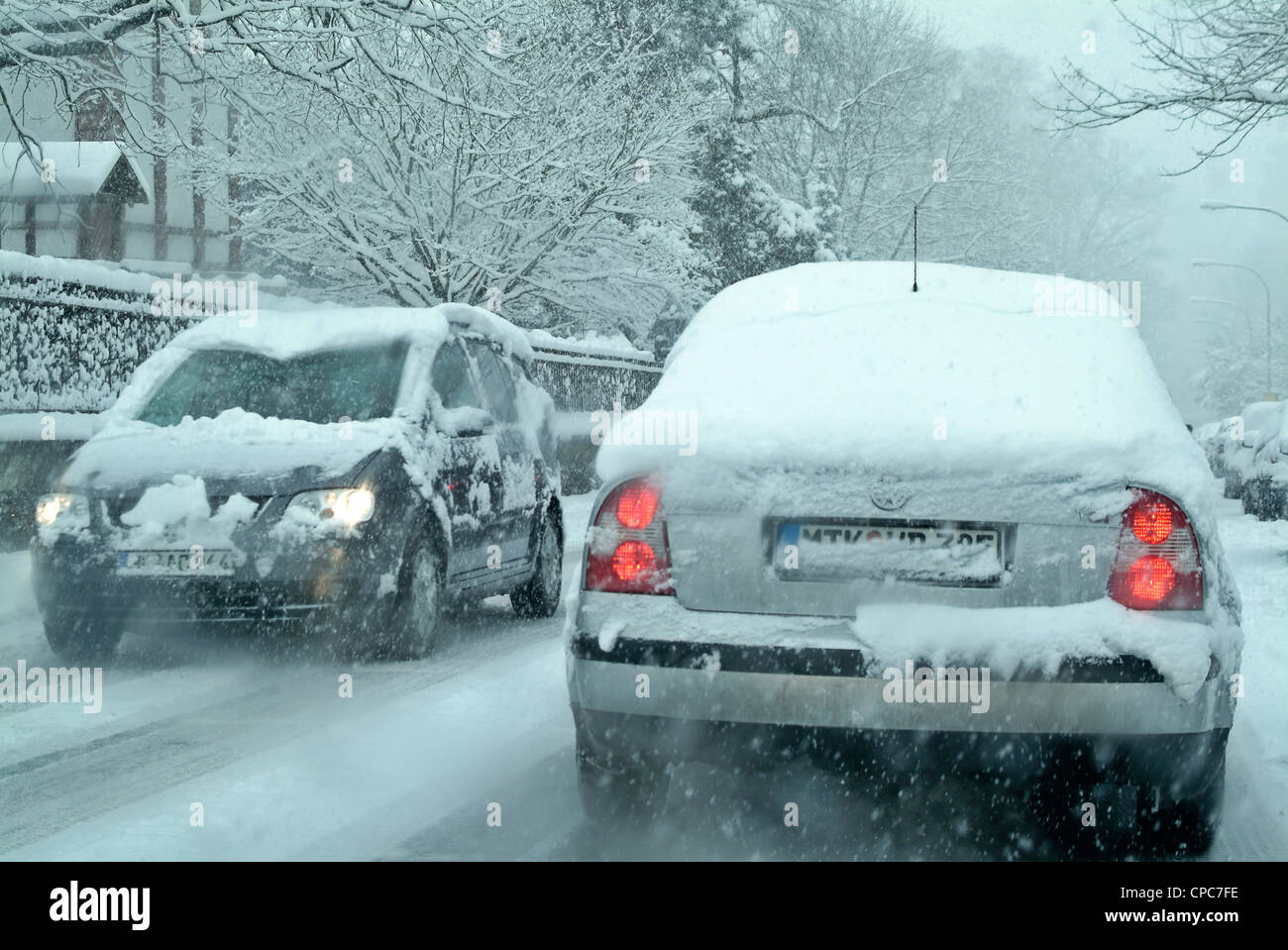 Schneebedeckte Autos auf einer Winter-Straße. Stockfoto