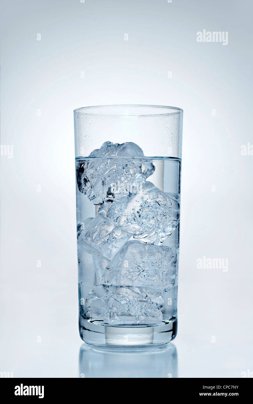 Trinken Sie mit Eiswürfeln vor einem blauen Hintergrund. Stockfoto