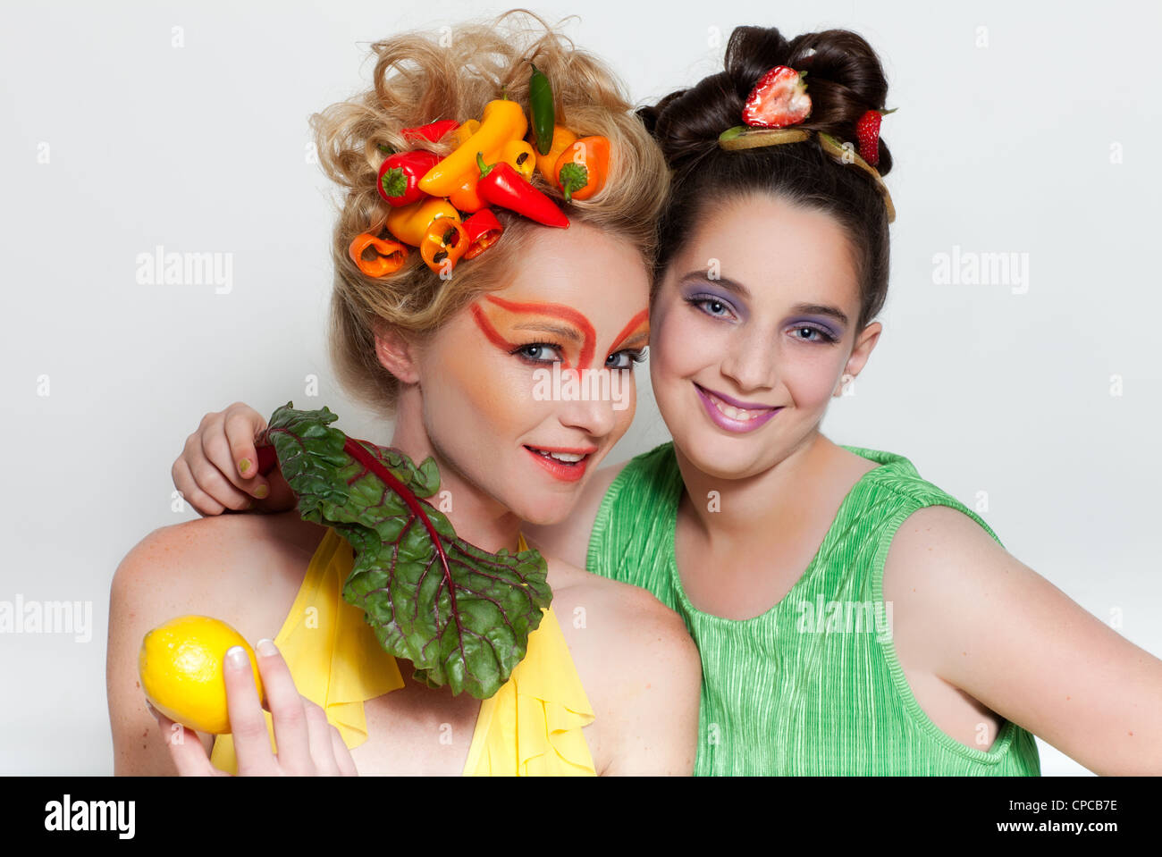 Schöne Frau und Kind mit einer Mischung aus frischem Gemüse und Obst und kreative make-up Stockfoto