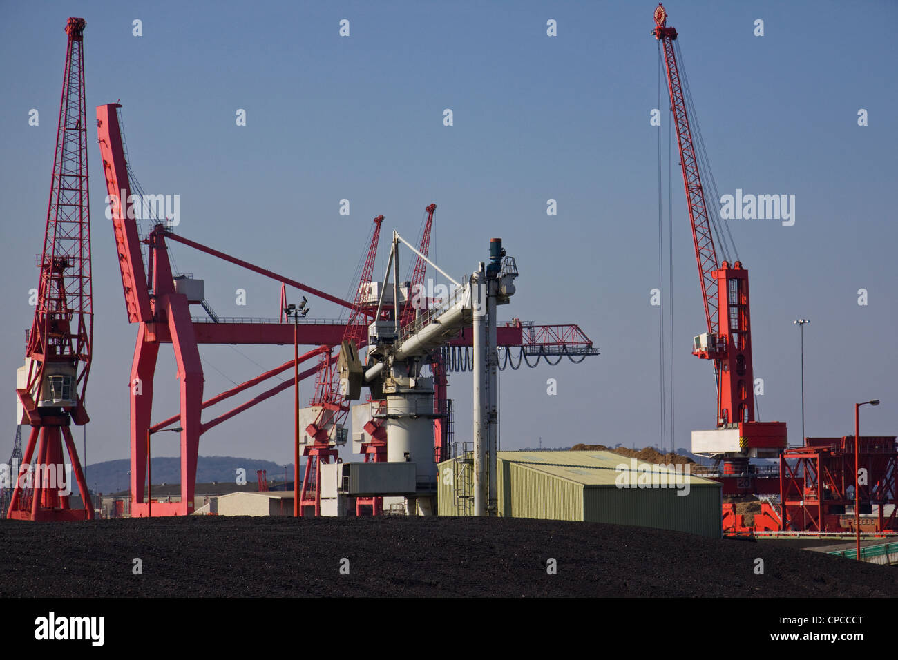 Dockside Maschinen und Haufen von importierter Kohle im Hafen Avonmouth, Bristol UK Stockfoto