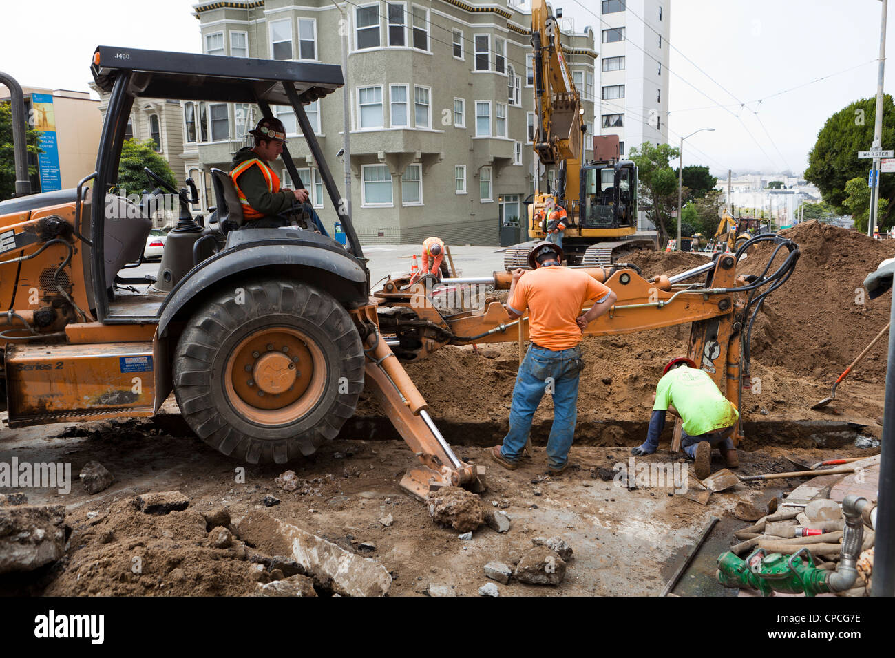 Kommunale Bauarbeiter und Bagger Graben Graben Stockfoto