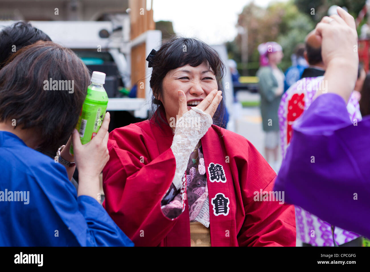 Eine japanische Frau, die ihr den Mund zu beim Lachen Stockfoto