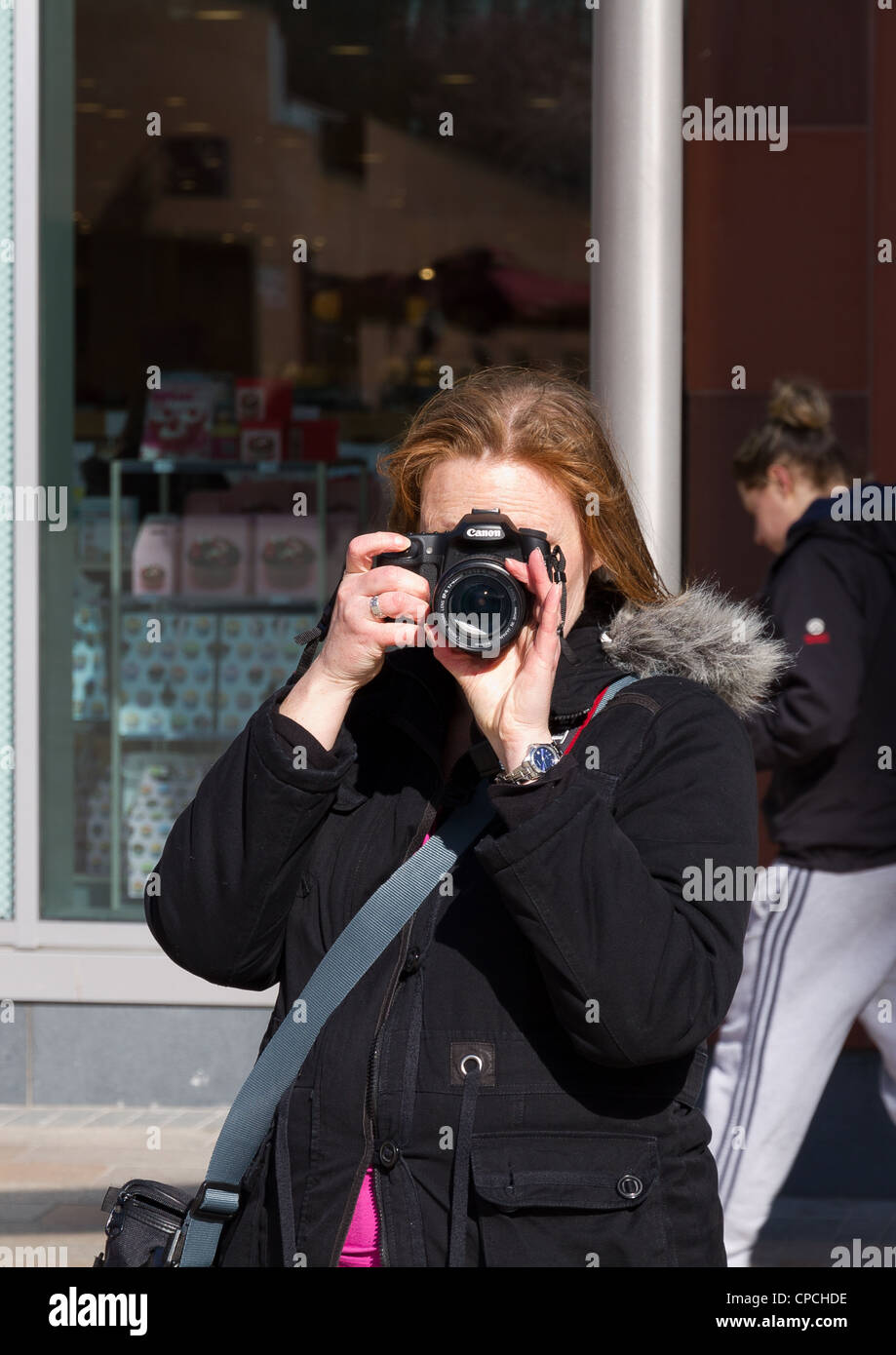 Frau nehmen Foto, Blick direkt in die Kamera Stockfoto