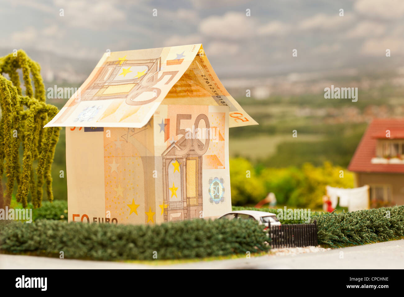 ein Euro-Rechnung-Haus in einer grünen Umgebung Landschaft Stockfoto