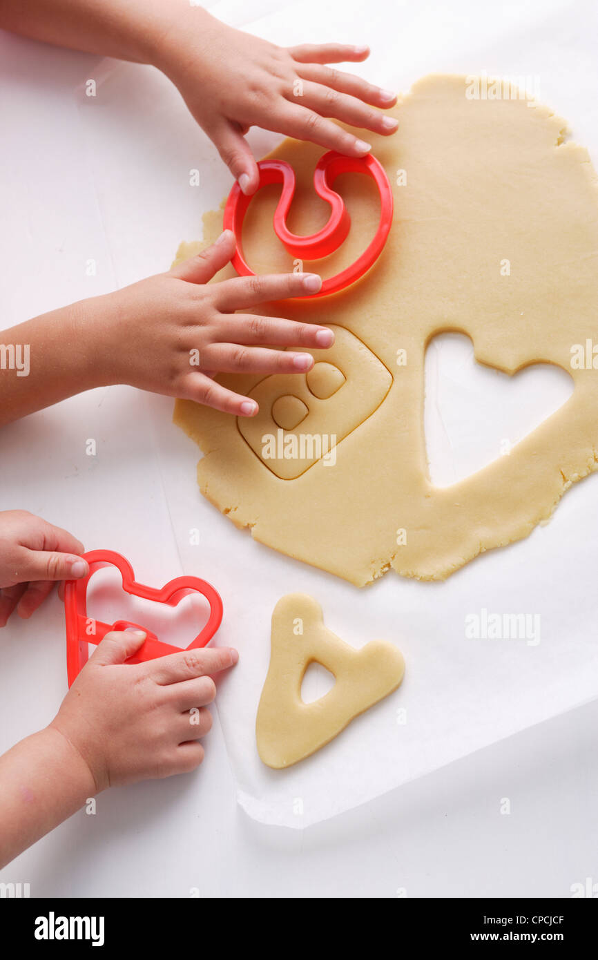 Kinder machen Cookies in Buchstabenformen Stockfoto